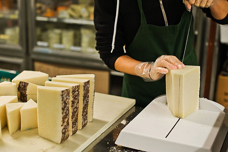 Slicing pecorino romano at cheese shop